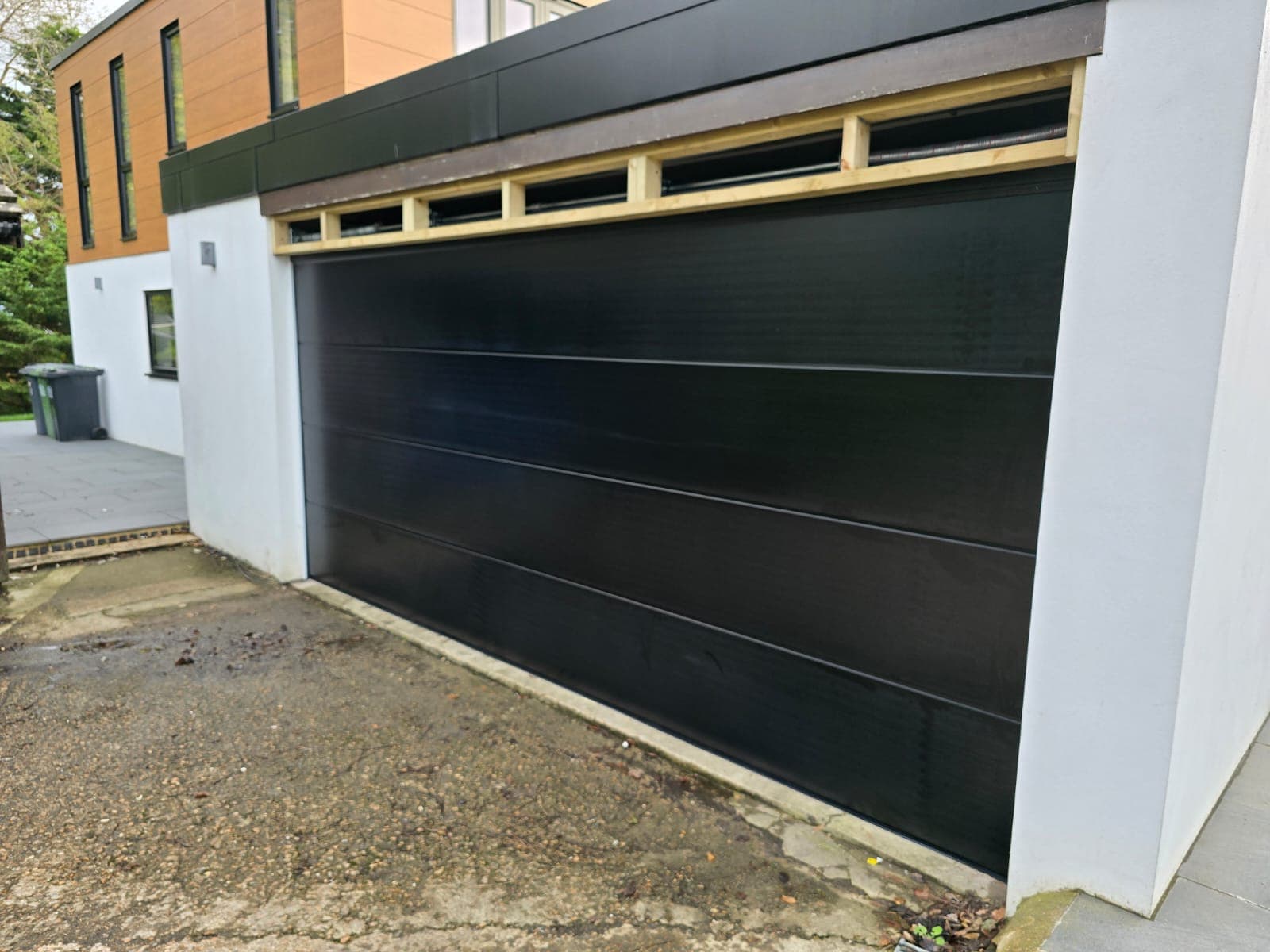 Large flush sectional garage door with ladder frame and uPVC trim finish